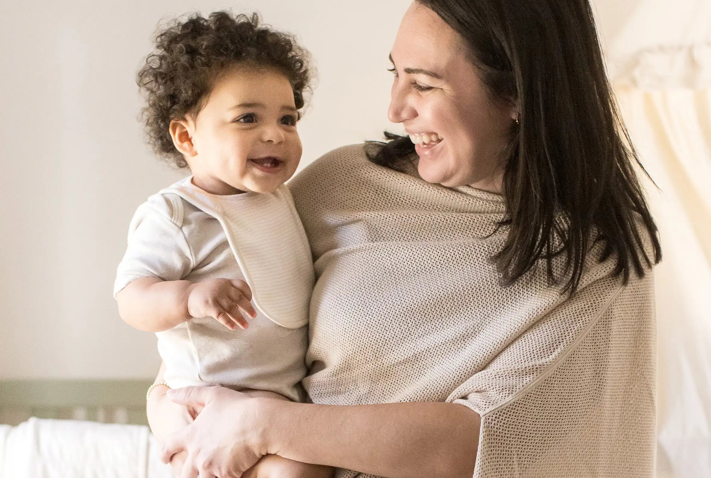 Parent holding a baby in soft organic cotton clothing